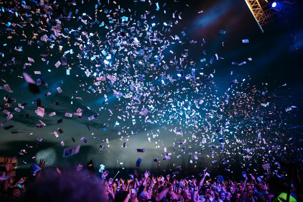 A packed crowd with raised hands at a night-time gospel concert